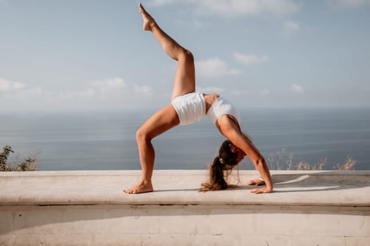 Fitness woman sea. Outdoor workout on yoga mat in park near to ocean beach. Female fitness pilates yoga routine concept. Healthy lifestyle. Happy fit woman exercising with rubber band in park.