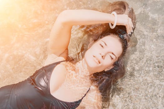 Woman travel sea. Young Happy woman in a long red dress posing on a beach near the sea on background of volcanic rocks, like in Iceland, sharing travel adventure journey