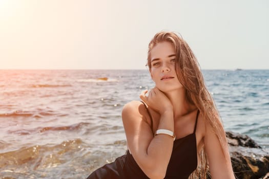 Woman travel sea. Young Happy woman in a long red dress posing on a beach near the sea on background of volcanic rocks, like in Iceland, sharing travel adventure journey