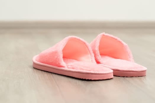 Slippers of pink colour in the room