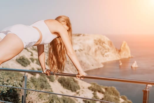 Fitness woman sea. Outdoor workout on yoga mat in park near to ocean beach. Female fitness pilates yoga routine concept. Healthy lifestyle. Happy fit woman exercising with rubber band in park.