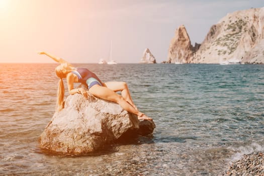 Woman travel sea. Young Happy woman in a long red dress posing on a beach near the sea on background of volcanic rocks, like in Iceland, sharing travel adventure journey