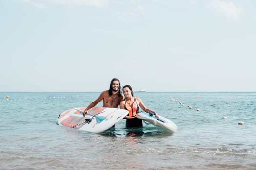 Woman man sea sup. Close up portrait of beautiful young caucasian woman with black hair and freckles looking at camera and smiling. Cute woman portrait in a pink bikini posing on sup board in the sea