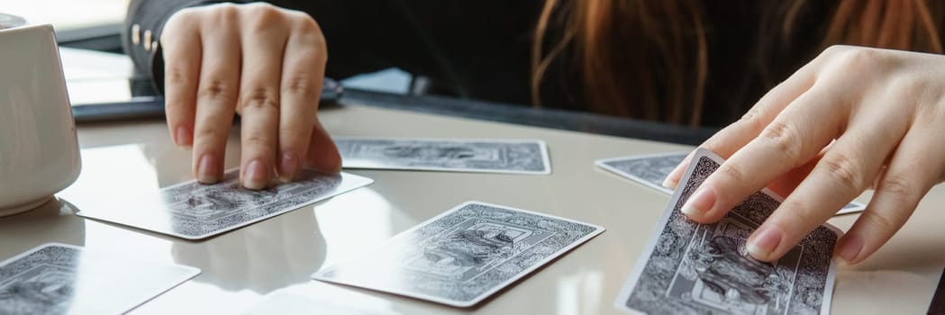 TVER, RUSSIA - FEBRUARY 11, 2023. Tarot cards, Tarot card divination, esoteric background. A woman makes a layout on the cards at the table. Divination, predictions on tarot cards