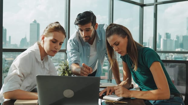 Group of skilled businesspeople sharing idea about marketing plan. Professional business team working together, discussing, talking at meeting table with laptop, document with cityscape. Tracery