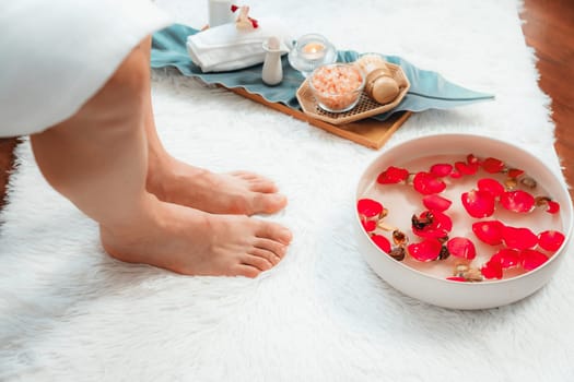 Woman indulges in blissful foot massage at luxurious spa salon while masseur give reflexology therapy in gentle day light ambiance resort or hotel foot spa. Quiescent