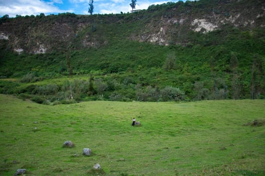 copyspace of natural canyon in ecuador full of vegetation, rocks, trees and a native woman dancing a native dance at the bottom of it. earth day. High quality photo