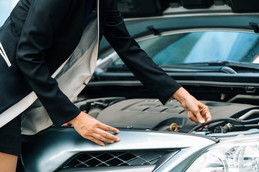 A business woman whose car breakdown try to fix the car by herself without help. uds