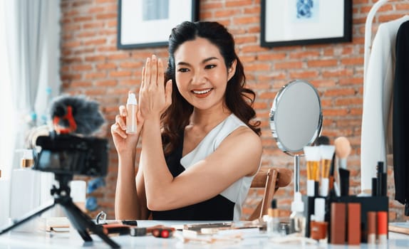 Asian Woman influencer shoot live streaming vlog video review makeup uttermost social media or blog. Happy young girl with cosmetics studio lighting for marketing recording session broadcasting online