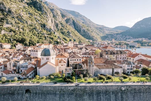 Church of St. Nicholas among old houses at the foot of the mountains. Kotor, Montenegro. Drone. High quality photo