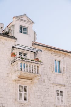 Ancient stone building with an attic and a carved small balcony. High quality photo