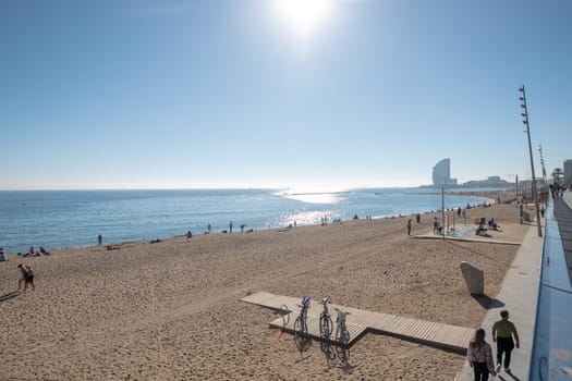 Barcelona, Spain: November 19, 2023: People in the Beach in Barcelona of La Barceloneta in the capital of Catalonia in Spain in 2023.