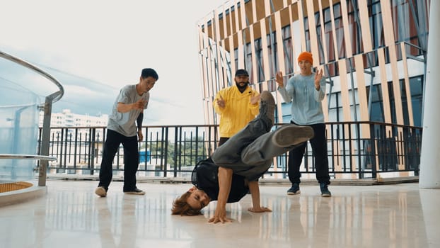 Hip hop team dance break dance while multicultural friend surrounded and clapping hands to cheer or encourage his friend to dance. Active and energetic street dance. Outdoor sport 2024. Endeavor.