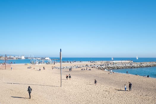 Barcelona, Spain: November 19, 2023: People in the Beach in Barcelona of La Barceloneta in the capital of Catalonia in Spain in 2023.