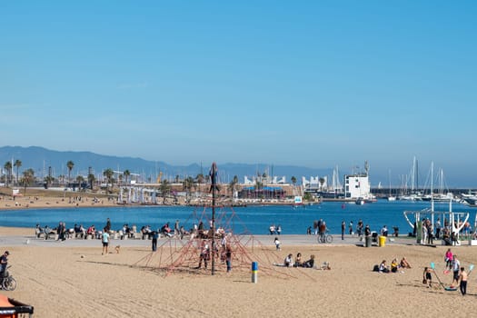 Barcelona, Spain: November 19, 2023: People in the Beach in Barcelona of La Barceloneta in the capital of Catalonia in Spain in 2023.