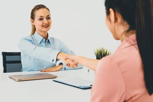 Two young business women in meeting at office table for job application and business agreement. Recruitment and human resources concept. uds