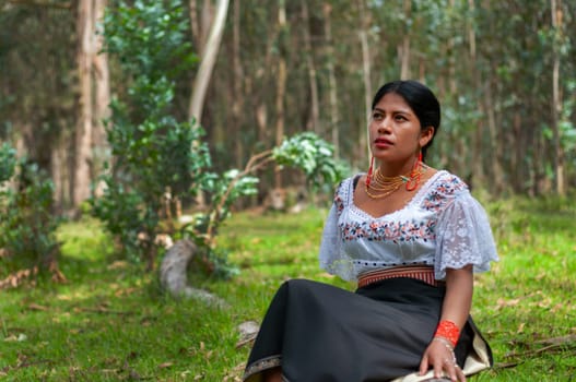copyspace of otavalena indian woman sitting in the middle of the tropical jungle of ecuador with traditional dress relaxing thinking in a place full of peace and harmony. earth day. High quality photo