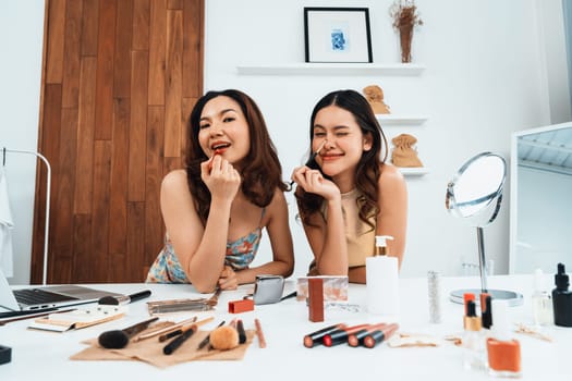 Asian Woman influencer shoot live streaming vlog video review makeup uttermost social media or blog. Happy young girl with cosmetics studio lighting for marketing recording session broadcasting online