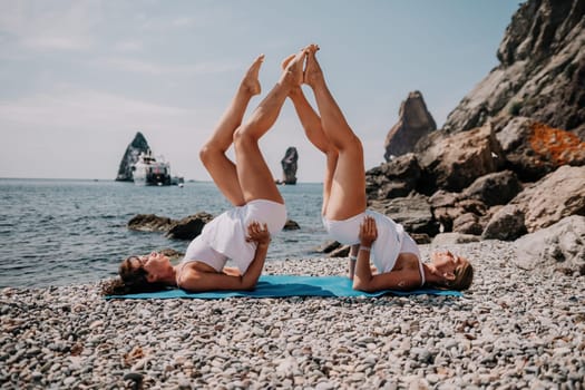 Woman sea yoga. Back view of free calm happy satisfied woman with long hair standing on top rock with yoga position against of sky by the sea. Healthy lifestyle outdoors in nature, fitness concept.