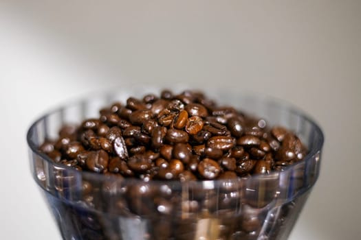 Coffee beans in a crystal jar on a white background. 