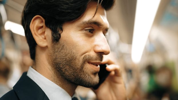 Closeup image of skilled business man face phone call to project manager in train with blurred background. Attractive caucasian investor talking to investor while standing at subway. Exultant.