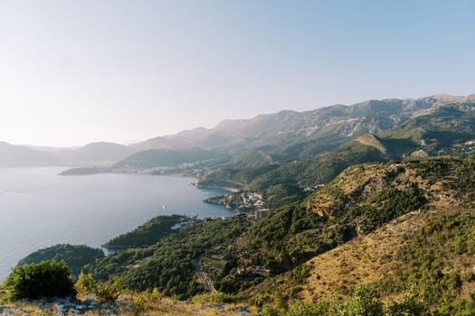 Blue bay at the foot of a mountain range against a clear horizon. High quality photo