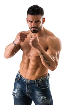 Handsome muscular man standing in boxing pose and looking at camera on white background.