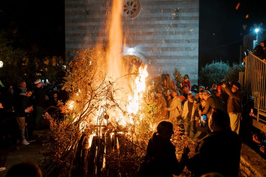 Crowds celebrate with a roaring oak branch bonfire outside an Orthodox church in Budva during Bozic festivities
