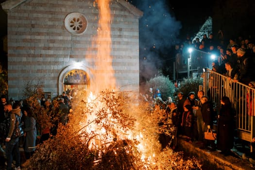 A festive scene unfolds in Budva's Old Town as locals set oak branches ablaze, honoring Orthodox Christmas Eve traditions
