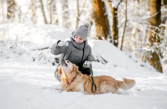 Teenage Girl Plays With Golden Retriever In Snowy Forest, Sitting With Dog