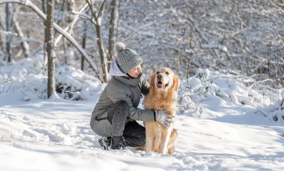 Girl, Teenager, And Golden Retriever Joyfully Play With Snow In Winter Forest