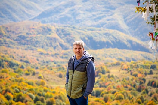 Man enjoying the view of autumn mountains, feeling the tranquility and majesty of nature
