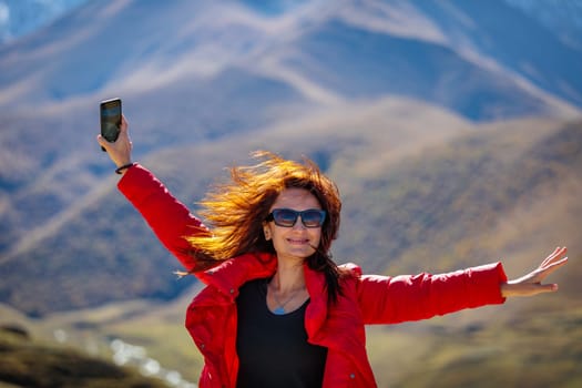 Young beauty posing in front of a snow-capped mountain peak