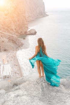 Woman sea trevel green dress. Side view a happy woman with long hair in a long mint dress posing on a beach with calm sea bokeh lights on sunny day. Girl on the nature on blue sky background