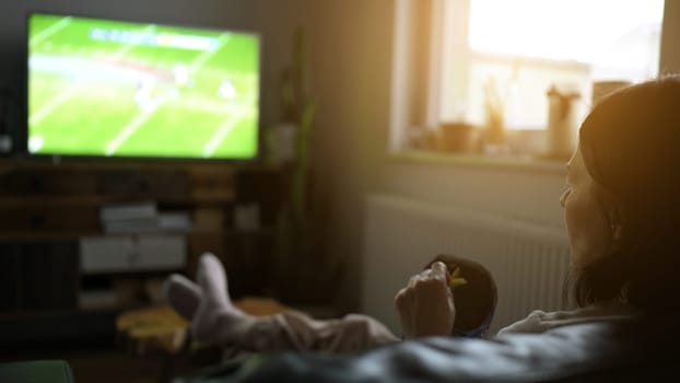 Girl watching football sport match by TV