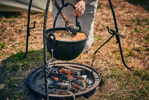 Camping. Soup in a pot over a fire. Stylization under the Middle Ages, vintage.