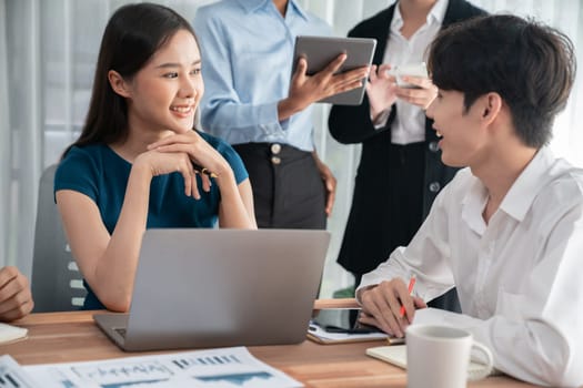 Multiracial analyst team use BI dashboard data to analyze financial report on meeting table. Group of diverse business people utilize data analysis by FIntech for success business marketing. Concord