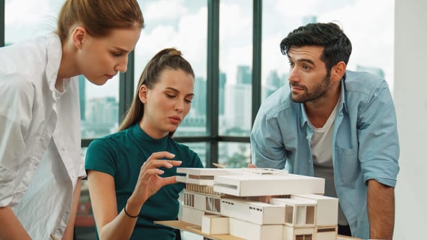 Smart architect team discussion about house design while handsome male worker present idea by using laptop. Group of professional engineer sharing, brainstorming design. Business design. Tracery