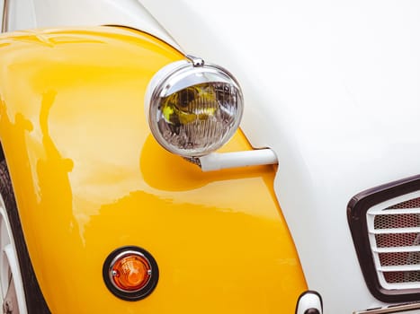 Classic retro car with close-up on headlights. Summer hot car parked on a beach