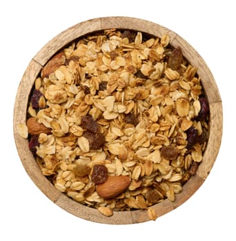 Oatmeal, raisins, cashews and almonds. Granola in wooden round plate, top view