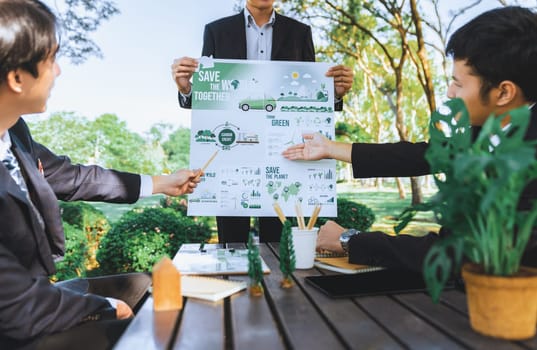 Group of asian business people presenting environmentally friendly development plan and sustainable technology project for greener future, establishing outdoor eco business office at natural park.Gyre