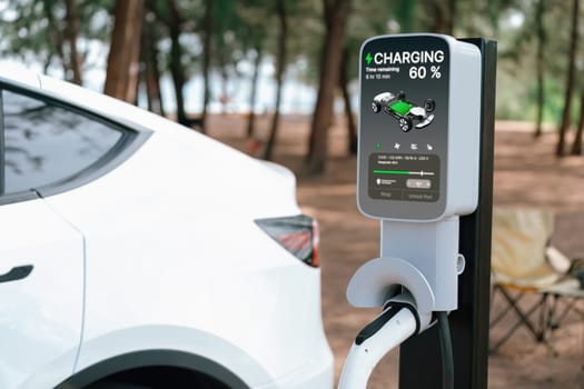 Electric car recharging battery at outdoor EV charging station at natural vacation campsite, alternative and sustainable energy technology eco-friendly car with holiday and travel concept. Perpetual