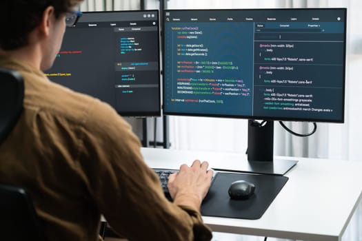 IT developer working online software development on pc monitors at modern home office on coding application screens, creating updated latest program firmware information version concept. Gusher.