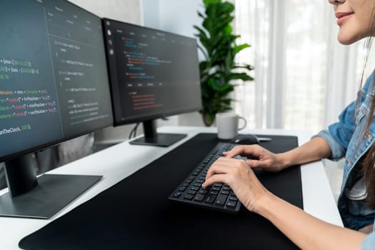 Young Asian in IT developer creating with typing online information on pc with coding program data of website application, wearing jeans shirt. surrounded by safety analysis two screens. Stratagem.