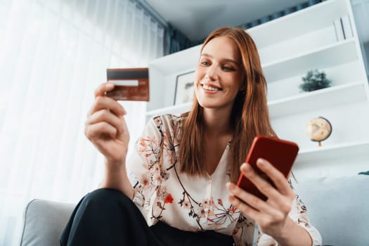 Young happy woman buy product by online shopping at home while ordering items from the internet with credit card online payment system protected by utmost cyber security from online store platform