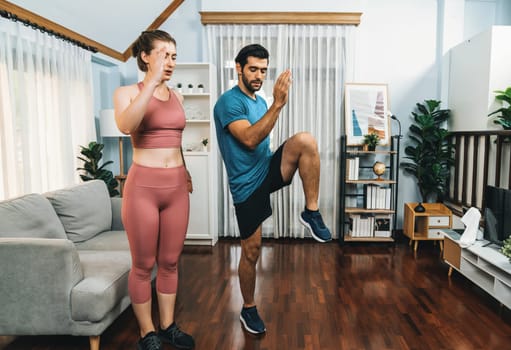 Athletic and sporty fitness couple or exercise buddy running posture at home body workout exercise session for fit physique and healthy sport lifestyle at home. Gaiety home exercise workout training.