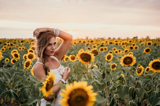 Woman in the sunflowers field. Summer time. Young beautiful woman standing in sunflower field.