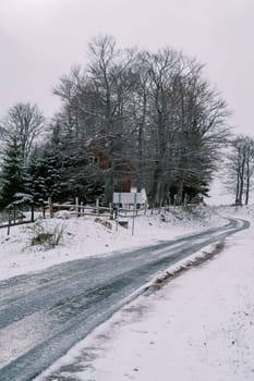 Icy road in a snowy village in the forest. High quality photo