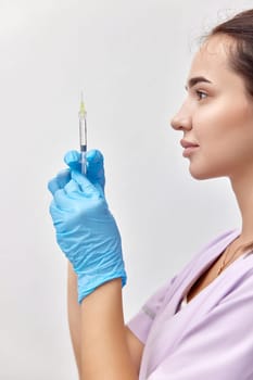 woman doctor in blue gloves with syringe for injection