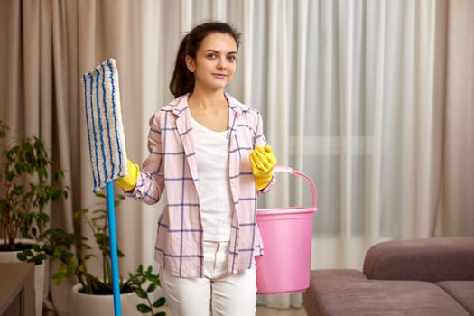 happy woman cleaning floor at living room, girl holding bucket and mop, daily housekeeping